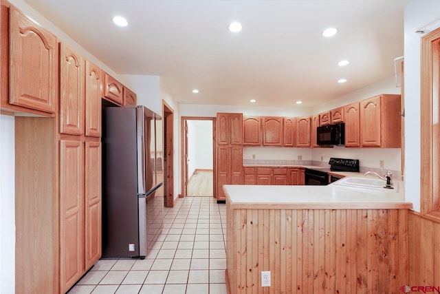 kitchen featuring recessed lighting, light tile patterned flooring, a sink, a peninsula, and black appliances