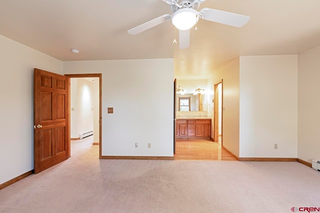 unfurnished bedroom with ensuite bathroom, a baseboard heating unit, ceiling fan, light carpet, and baseboards