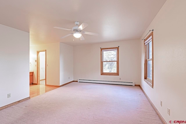 unfurnished room with a baseboard heating unit, light carpet, ceiling fan, and baseboards