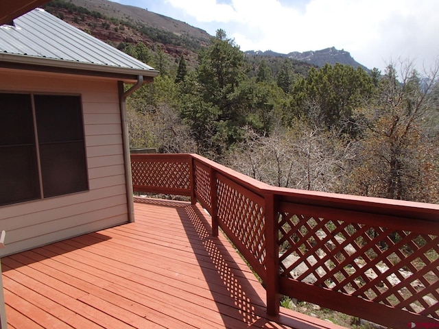 deck with a wooded view and a mountain view