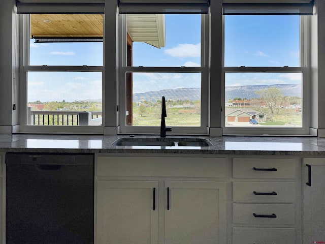 710 SE Pine St, Cedaredge, CO 81413 - kitchen featuring black dishwasher, a sink, white cabinetry, and dark stone countertops