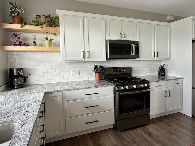 710 SE Pine St, Cedaredge, CO 81413 - kitchen with appliances with stainless steel finishes, white cabinetry, open shelves, backsplash, and dark wood-style floors
