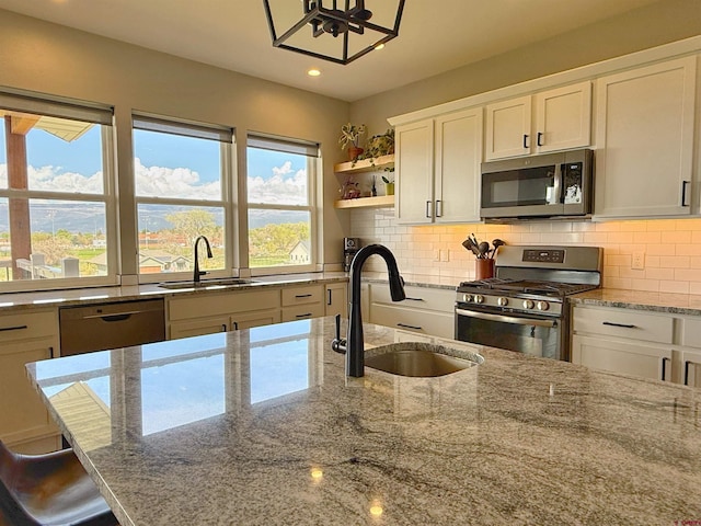 710 SE Pine St, Cedaredge, CO 81413 - kitchen with stainless steel appliances, a sink, recessed lighting, white cabinetry, and light stone countertops