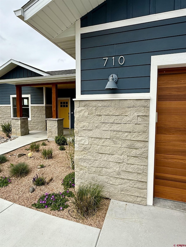 710 SE Pine St, Cedaredge, CO 81413 - doorway to property featuring stone siding, a porch, and board and batten siding