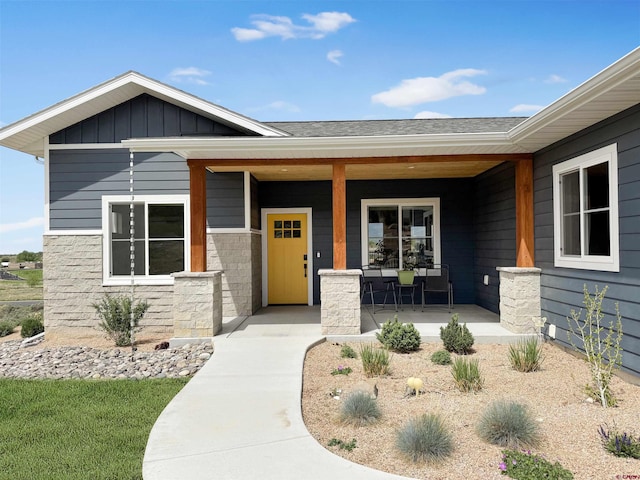 710 SE Pine St, Cedaredge, CO 81413 - view of exterior entry featuring covered porch, stone siding, and board and batten siding