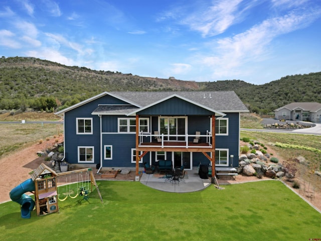 710 SE Pine St, Cedaredge, CO 81413 - rear view of property featuring a mountain view, a yard, a patio area, and a playground