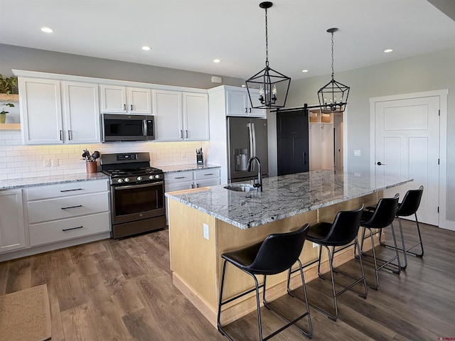 710 SE Pine St, Cedaredge, CO 81413 - kitchen with appliances with stainless steel finishes, a sink, white cabinets, dark wood-style floors, and tasteful backsplash