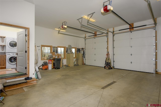 garage with stacked washer and clothes dryer and a garage door opener