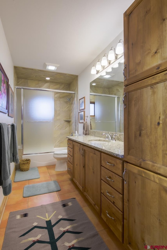 full bathroom featuring an enclosed shower, vanity, toilet, and tile patterned flooring