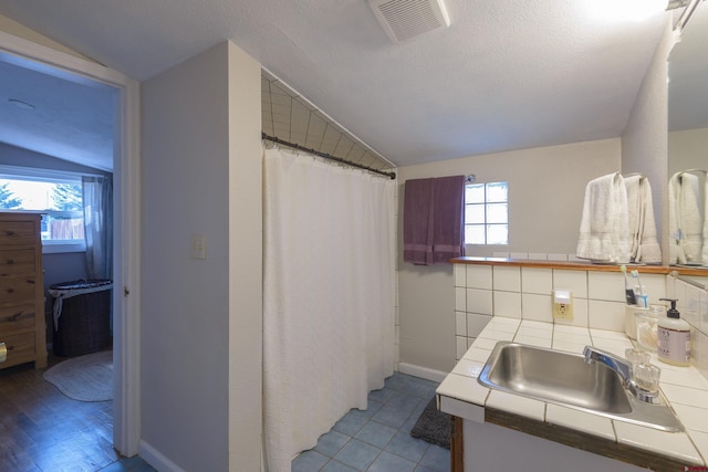 full bath featuring lofted ceiling, vanity, baseboards, and a shower with curtain