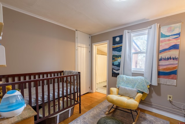 bedroom with ornamental molding and light wood-style flooring