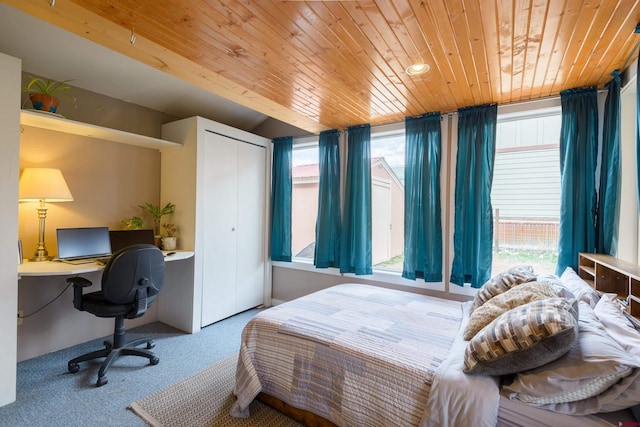carpeted bedroom with wood ceiling, a desk, and a closet