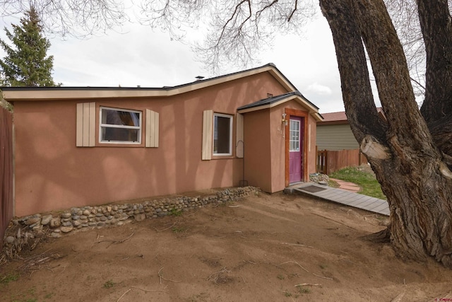 view of front of property featuring stucco siding and fence