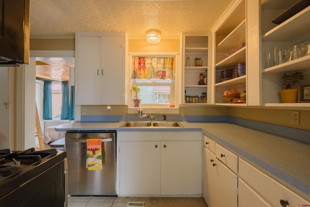 kitchen with stainless steel dishwasher, a sink, black gas range, white cabinetry, and a textured ceiling