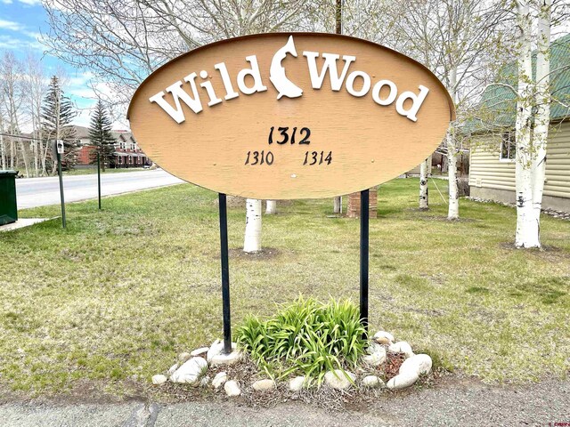 community / neighborhood sign featuring a lawn