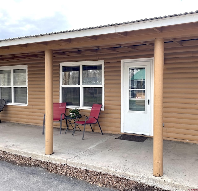 doorway to property featuring a patio and metal roof