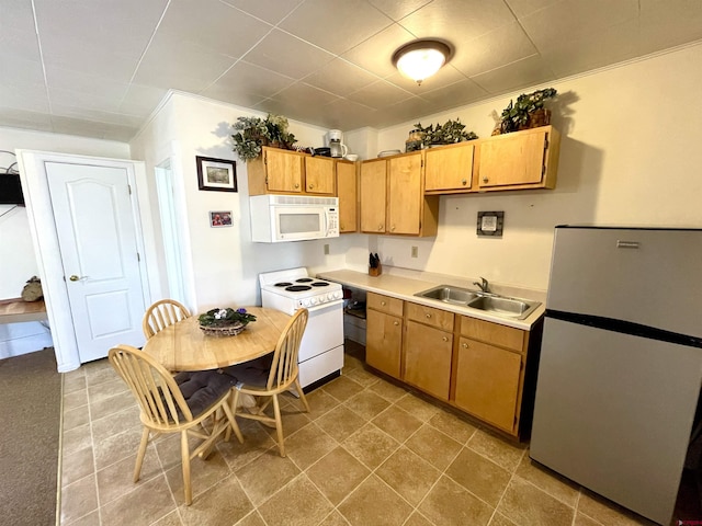 kitchen with white appliances, a sink, and light countertops