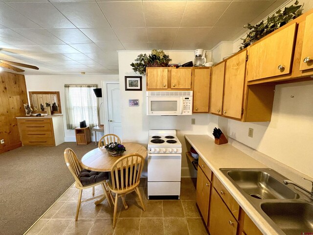 kitchen with white appliances, a sink, ceiling fan, light countertops, and brown cabinets