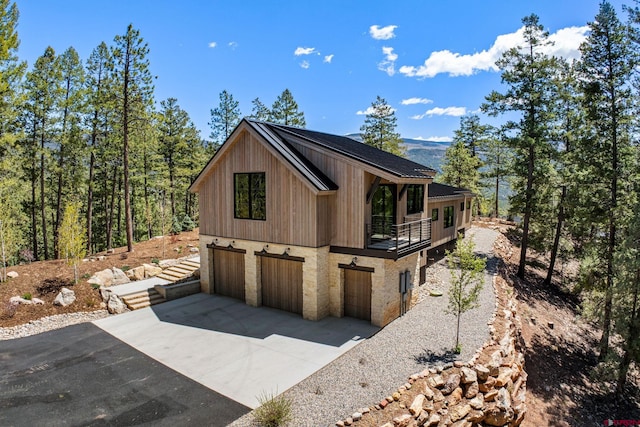 49 Bluff Dr, Durango, CO 81301 - view of home's exterior with concrete driveway, an attached garage, and a balcony