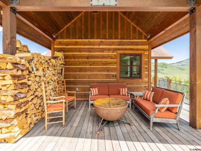 wooden deck with an outdoor hangout area and a mountain view