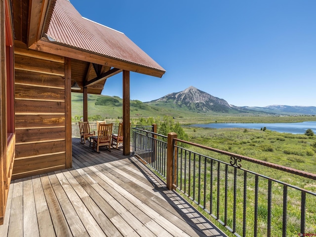 wooden terrace featuring a water and mountain view