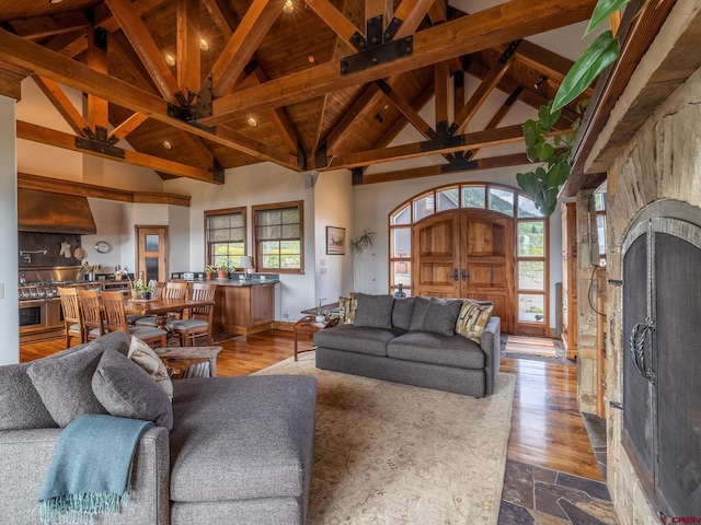 living area with beam ceiling, high vaulted ceiling, dark wood-style floors, and wood ceiling