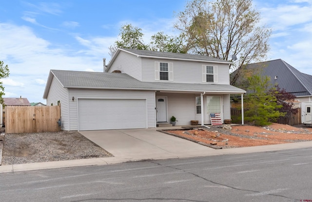 traditional-style house featuring a garage, concrete driveway, fence, and a porch