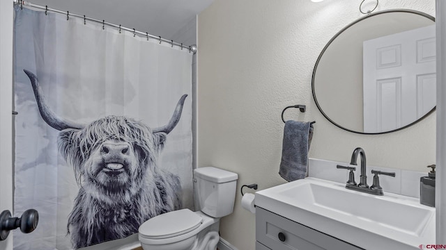 bathroom featuring toilet, vanity, baseboards, and a shower with shower curtain