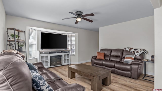 living area with wood finished floors, ceiling fan, and baseboards