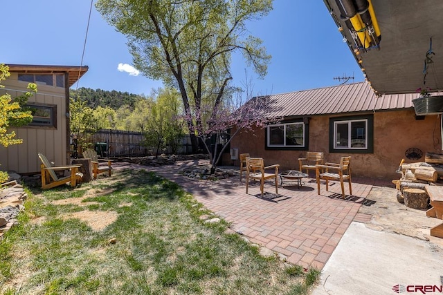 view of yard featuring an outdoor fire pit, fence, and a patio area