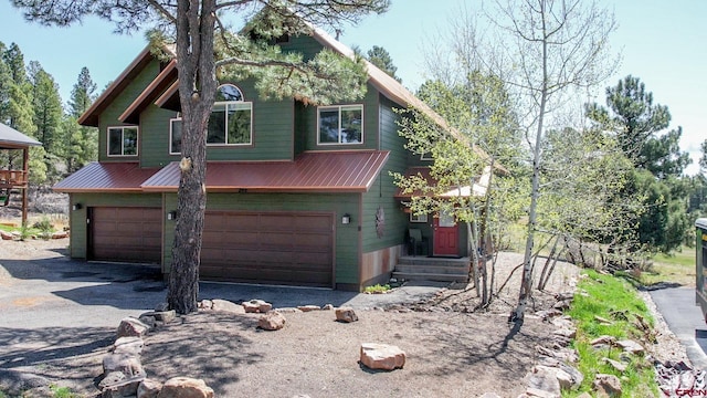 292 E Golf Pl Unit B, Pagosa Springs, CO 81147 - view of front facade featuring metal roof, a garage, and driveway