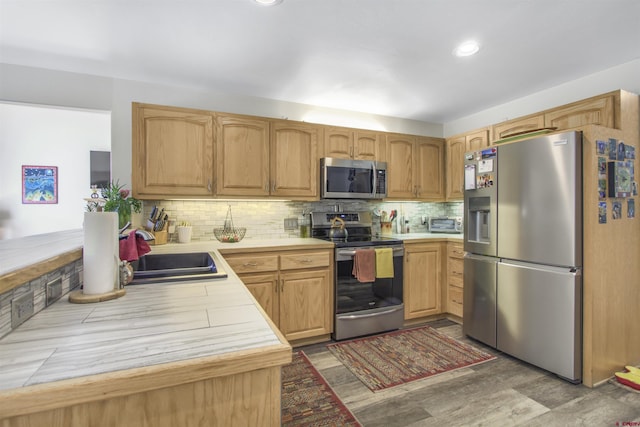292 E Golf Pl Unit B, Pagosa Springs, CO 81147 - kitchen featuring stainless steel appliances, tasteful backsplash, light wood-type flooring, light countertops, and a sink
