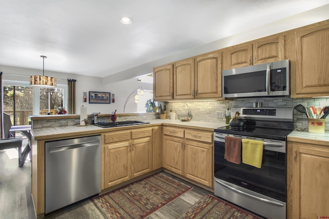 292 E Golf Pl Unit B, Pagosa Springs, CO 81147 - kitchen with appliances with stainless steel finishes, a sink, a peninsula, dark wood-style flooring, and tile countertops
