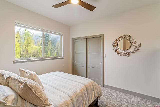 carpeted bedroom featuring a ceiling fan and a closet