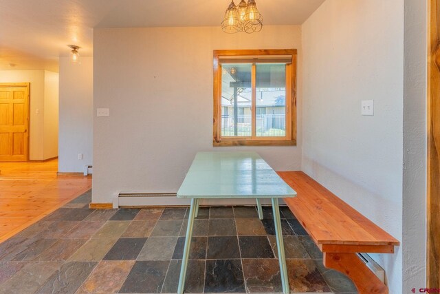 169 Camino Del Rio Unit 8, Gunnison, CO 81230 - unfurnished dining area featuring a chandelier, baseboards, stone finish floors, and baseboard heating