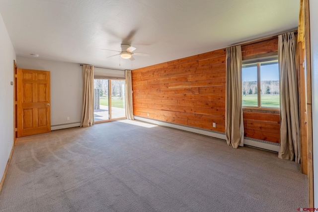 169 Camino Del Rio Unit 8, Gunnison, CO 81230 - empty room featuring ceiling fan, a baseboard heating unit, carpet flooring, and wood walls