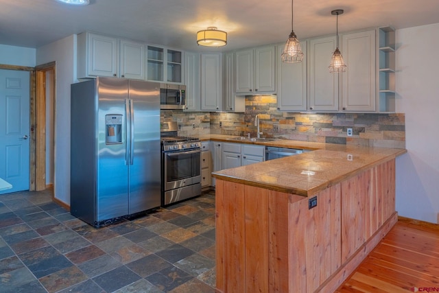 169 Camino Del Rio Unit 8, Gunnison, CO 81230 - kitchen featuring appliances with stainless steel finishes, open shelves, a peninsula, tile countertops, and a sink