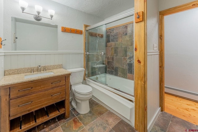 169 Camino Del Rio Unit 8, Gunnison, CO 81230 - bathroom with stone tile flooring, toilet, a textured ceiling, enclosed tub / shower combo, and a wainscoted wall