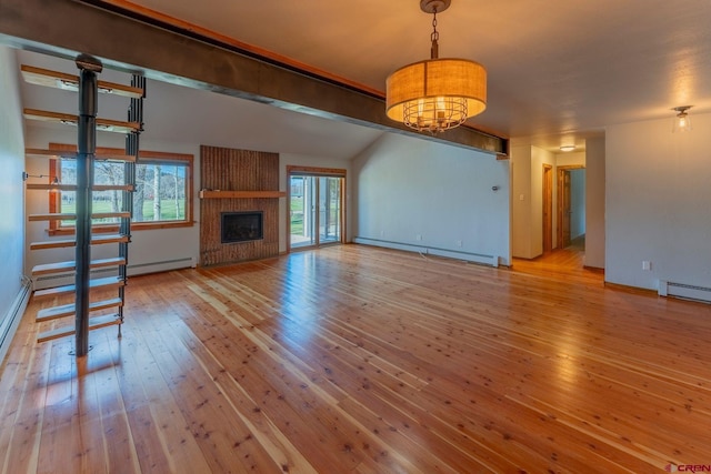 169 Camino Del Rio Unit 8, Gunnison, CO 81230 - unfurnished living room featuring a baseboard heating unit, hardwood / wood-style flooring, a fireplace, a baseboard radiator, and baseboards