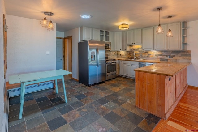 169 Camino Del Rio Unit 8, Gunnison, CO 81230 - kitchen featuring appliances with stainless steel finishes, a peninsula, tasteful backsplash, open shelves, and pendant lighting