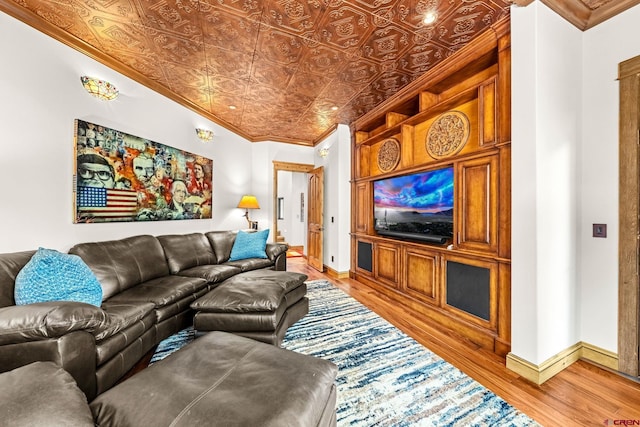 living room with an ornate ceiling, ornamental molding, light wood finished floors, and baseboards