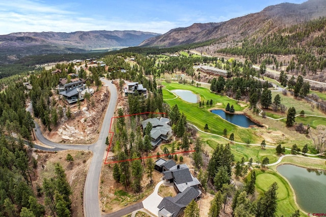 aerial view of residential area with a water and mountain view, a golf club, and property parcel outlined