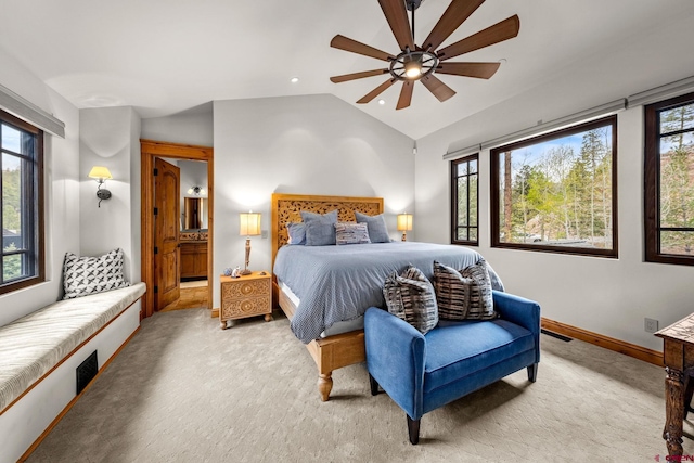 bedroom featuring light colored carpet, lofted ceiling, baseboards, connected bathroom, and ceiling fan