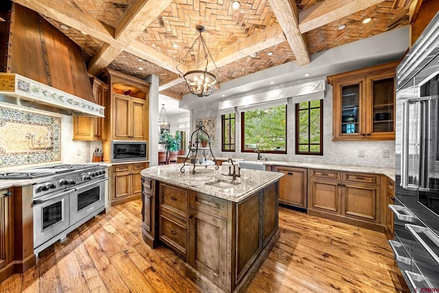 kitchen with high end appliances, a chandelier, a sink, light wood-style flooring, and brick ceiling