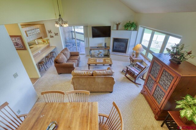 301 Talisman Dr Unit 4319, Pagosa Springs, CO 81147 - carpeted living room featuring a glass covered fireplace, plenty of natural light, high vaulted ceiling, and a chandelier