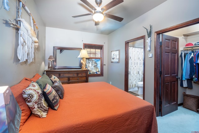 carpeted bedroom with a walk in closet, ensuite bathroom, a closet, and a ceiling fan