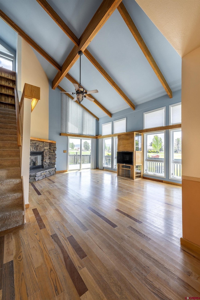 16303 6760th Rd, Montrose, CO 81401 - unfurnished living room featuring a fireplace, a ceiling fan, stairs, beamed ceiling, and wood finished floors