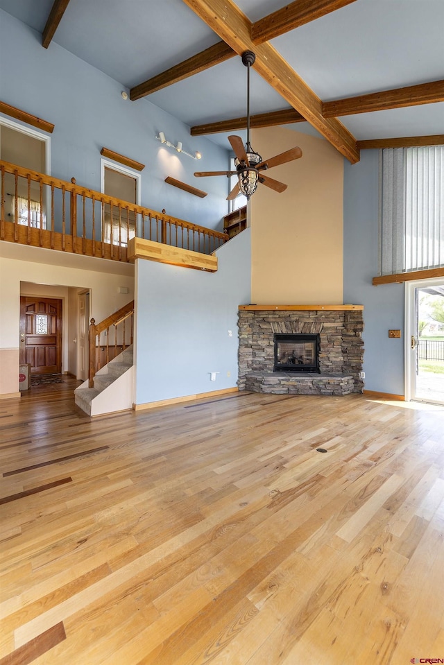 16303 6760th Rd, Montrose, CO 81401 - unfurnished living room with a ceiling fan, a high ceiling, baseboards, beamed ceiling, and a fireplace