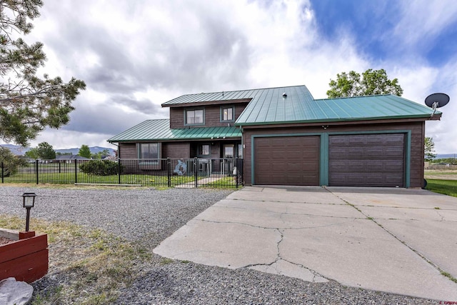 16303 6760th Rd, Montrose, CO 81401 - view of front of house with concrete driveway, a garage, fence, metal roof, and a standing seam roof