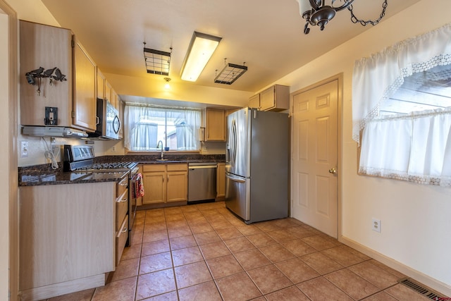 16303 6760th Rd, Montrose, CO 81401 - kitchen with stainless steel appliances, light tile patterned floors, a sink, and dark stone counters